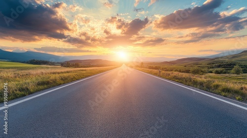 Empty Asphalt Road Leading Towards Sunset Over Rolling Hills