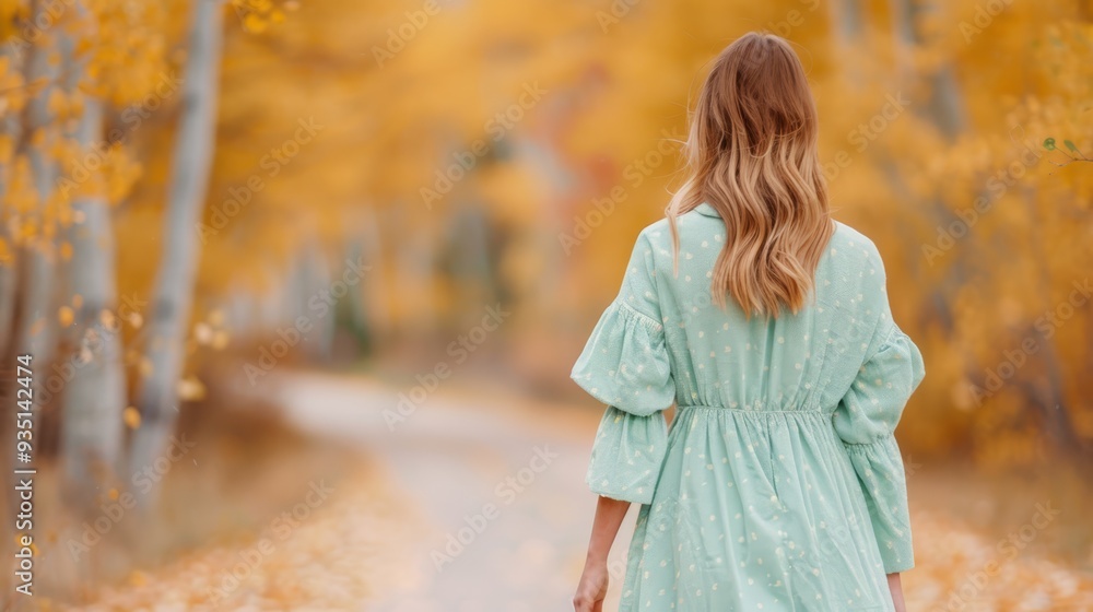 A woman carries a suitcase in each hand as she walks down a woodland path, dressed in blue A woman carries a suitcase in each hand as she walks down a woodland path, dressed in blue