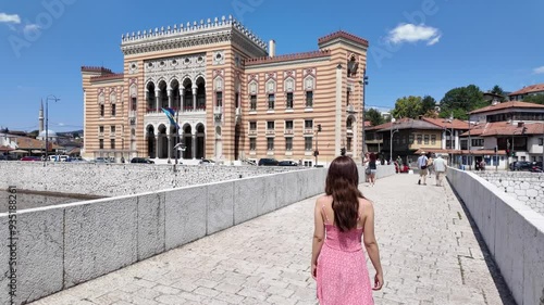 Female tourist walks on a bridge to the City Hall of Sarajevo, Bosnia Herzegovina. 
