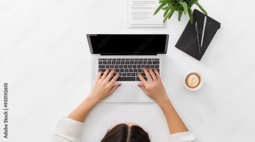 Typing on laptop near plant and coffee cup