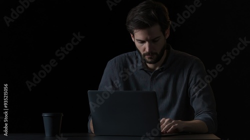 Man working on a laptop in dark setting