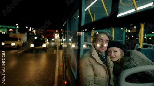 A couple sharing a memorable moment together on a night bus journey in an urban setting