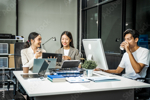 Asian colleagues meet at a desk, discussing business financial terms, investment strategies, managing funds. Their focus is on planning, analysis, and operations to ensure stability and success.