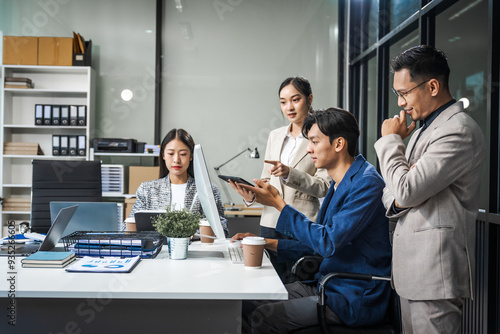 Asian colleagues meet at a desk, discussing business financial terms, investment strategies, managing funds. Their focus is on planning, analysis, and operations to ensure stability and success.