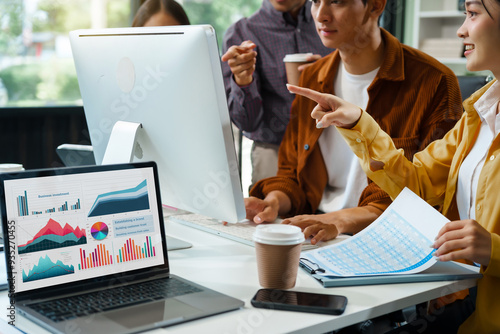 In a boardroom, an Asian team discusses startup financials and business terms. They present strategies on acquisitions, cash flow, and investor relations, innovative approaches for company growth. photo