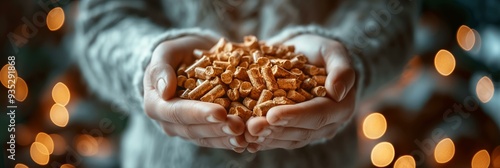 Woman in green jacket holding wood pellets in winter snow, sustainable heating solution photo