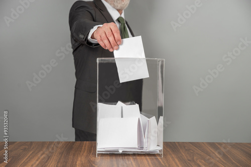 Fotografie A voter casting a ballot into a ballot box on election day
