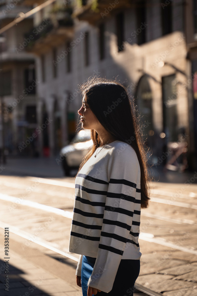 Fototapeta premium Portrait of a girl in a sunrise golden hour morning in Milan, Italy, Europe