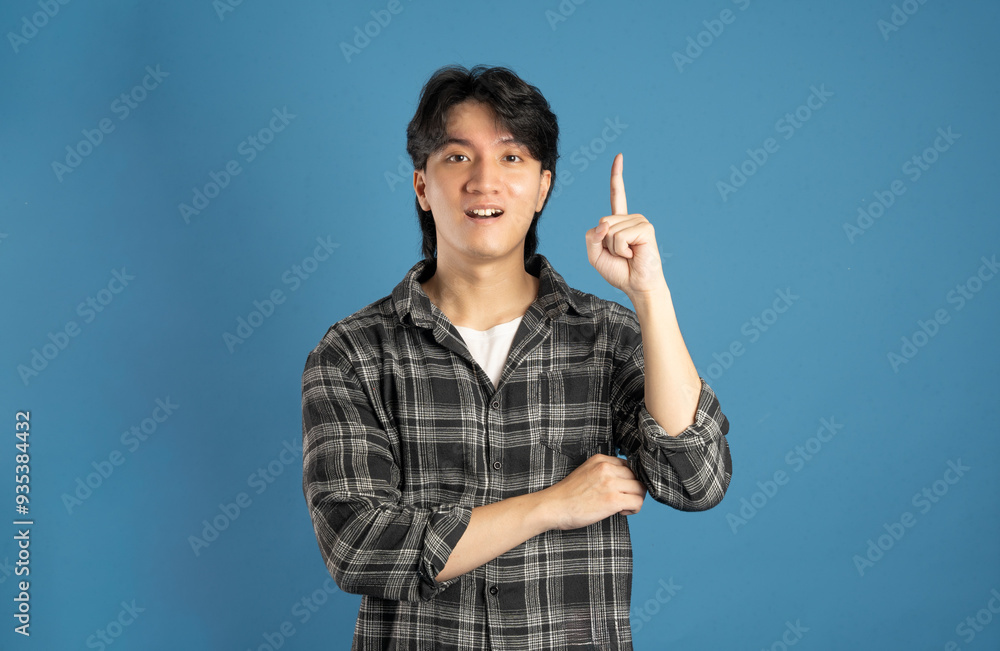 Portrait of Asian male student posing on blue background Portrait of Asian male student posing on blue background