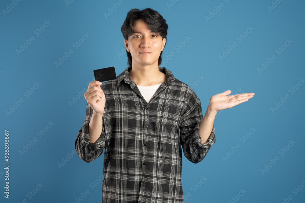Portrait of Asian male student posing on blue background Portrait of Asian male student posing on blue background