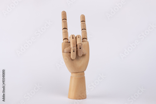 Wooden hand making the rock symbol. Isolated on white background. Copy Space. Concept of symbol, gesture and sign