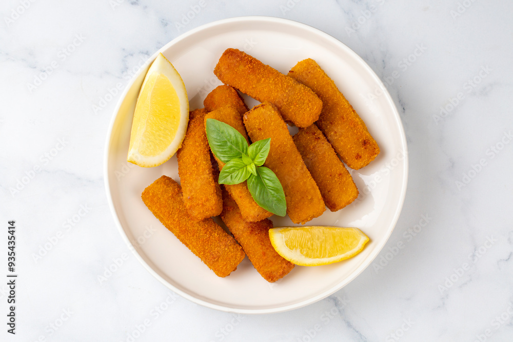 Fish and chips .Close up of crispy breaded deep fried fish fingers with breadcrumbs served with remoulade sauce and lemon