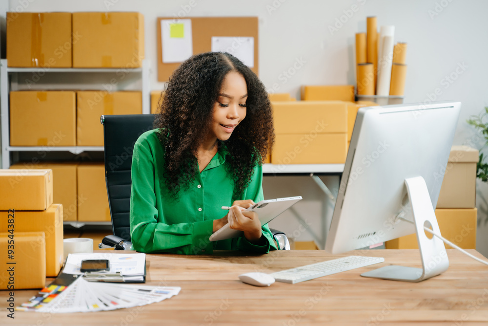 Young business owner woman prepare parcel box and standing check online orders for deliver Young business owner woman prepare parcel box and standing check online orders for deliver