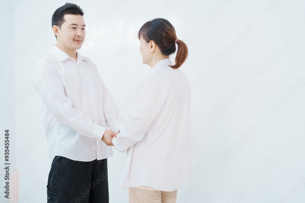 A happy Asian couple, expecting a baby, embraces in a cozy living room. The pregnant woman smiles warmly, while the man lovingly supports her, capturing a moment of joyful anticipation. A happy Asian couple, expecting a baby, embraces in a cozy living room. The pregnant woman smiles warmly, while the man lovingly supports her, capturing a moment of joyful anticipation.