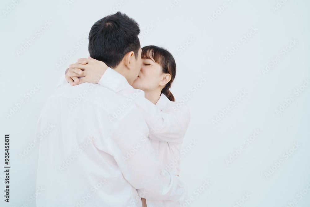 A happy Asian couple, expecting a baby, embraces in a cozy living room. The pregnant woman smiles warmly, while the man lovingly supports her, capturing a moment of joyful anticipation. A happy Asian couple, expecting a baby, embraces in a cozy living room. The pregnant woman smiles warmly, while the man lovingly supports her, capturing a moment of joyful anticipation.