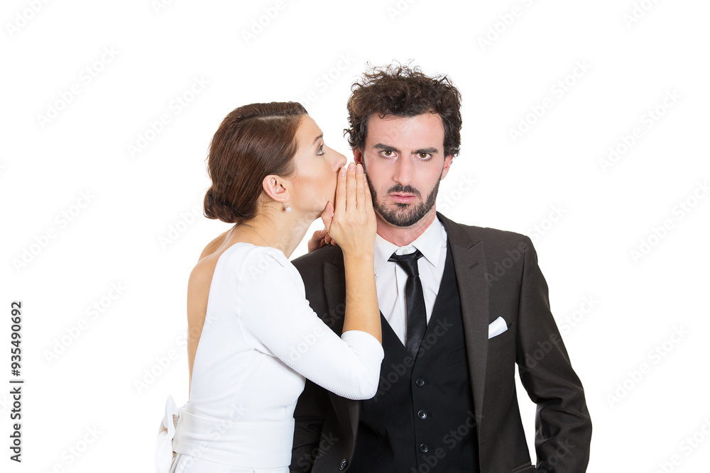 Young woman whispering a secret to a serious businessman Young woman whispering a secret to a serious businessman