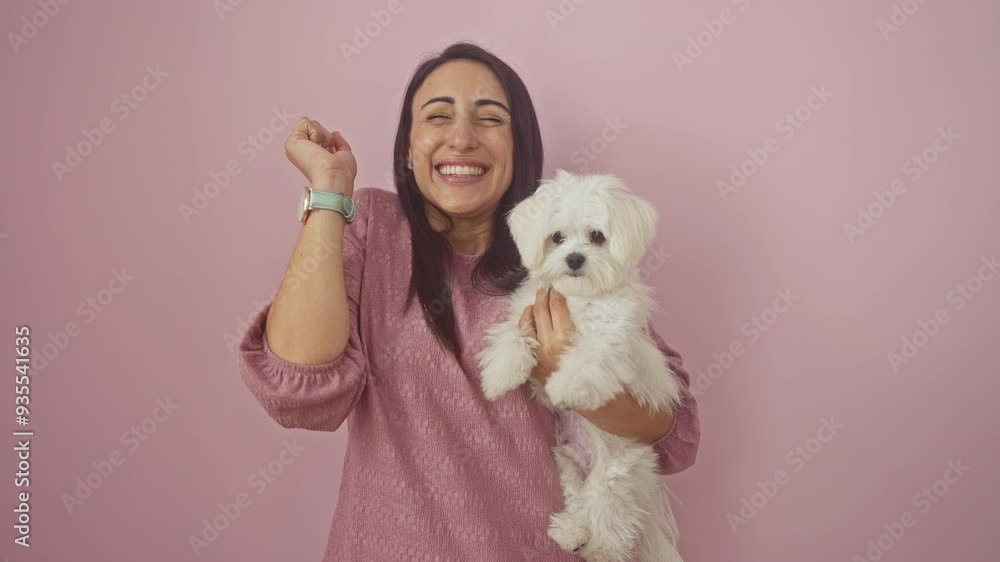 Young hispanic woman with her dog, standing over isolated pink background, celebrating a happy win with a cheerful smile, an expression of achievement and victory Young hispanic woman with her dog, standing over isolated pink background, celebrating a happy win with a cheerful smile, an expression of achievement and victory