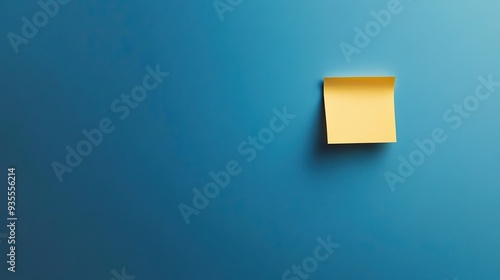 Minimalist blue background featuring a single yellow sticky note, perfectly placed and slightly curled