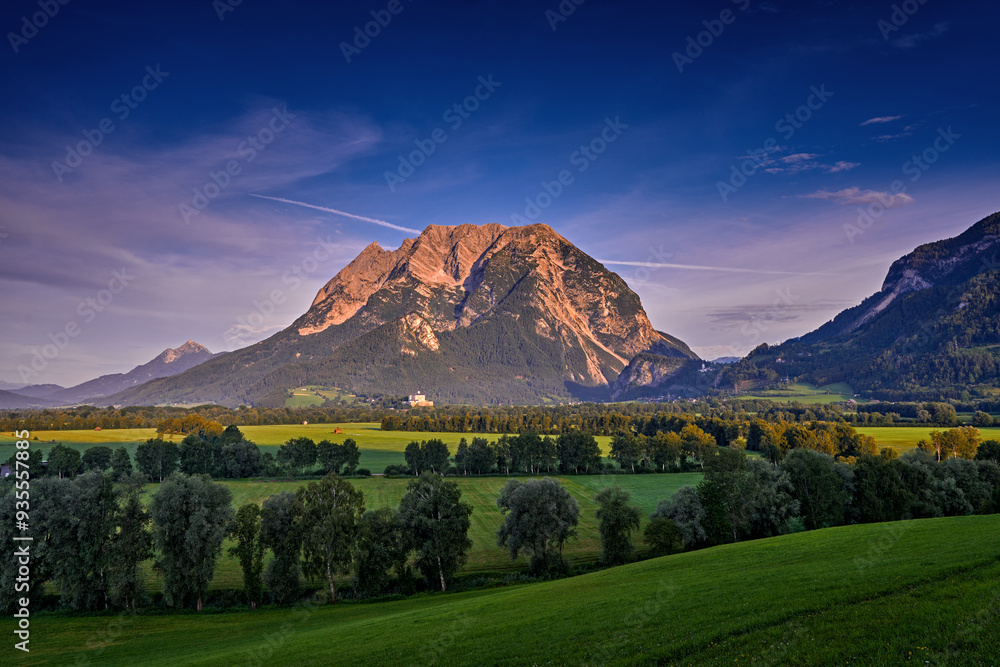 Fototapeta premium Mountain sunrise. Grimming (2351m) peak in the Dachstein Mountains of Austria, ultra-prominent mountains of Alps. Morning in Europe. Hill with first pink sun ray on the rock. Summer Austria.