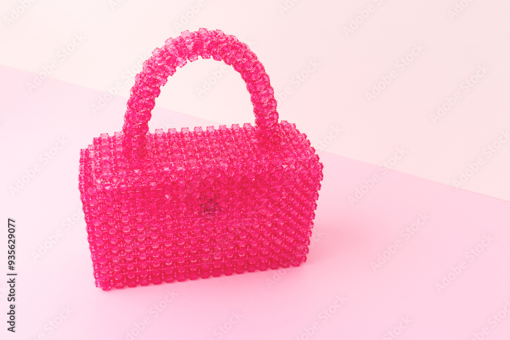 Handmade bag made from acrylic beads on a beige and pink background with place for text. Handmade bag made from acrylic beads on a beige and pink background with place for text.