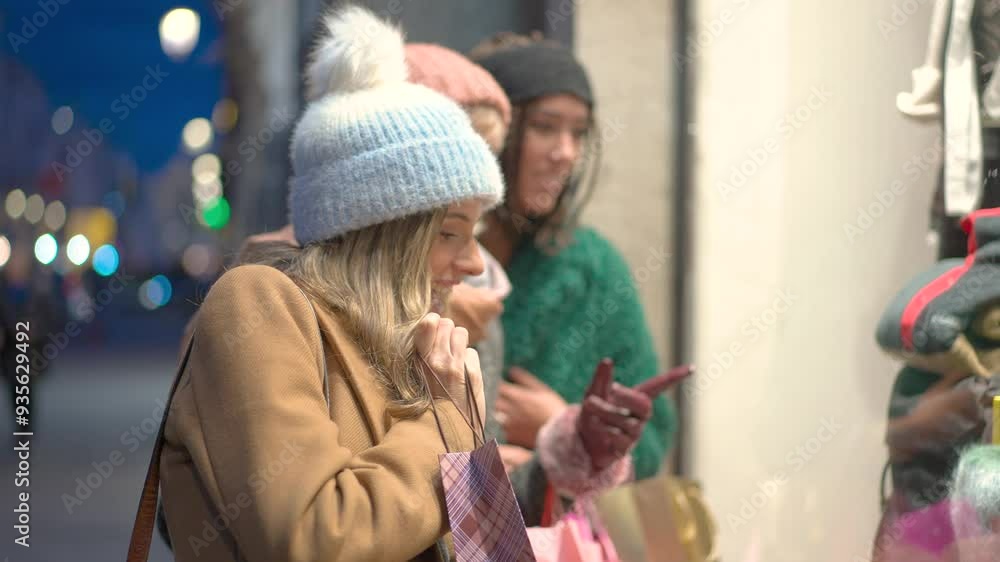 Happy women pointing at shop window displaying christmas gifts in slow motion Happy women pointing at shop window displaying christmas gifts in slow motion