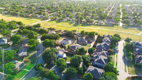 Residential neighborhood near open space trail, concrete pathway boundary with overhead utility right-of-way high voltage power lines in West Plano, suburbs Dallas, lush tree lined street, aerial