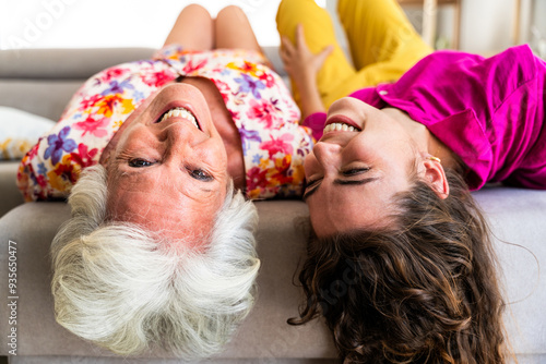 Fotografie Beautiful grandmother and granddaughter together at home having fun and laughing