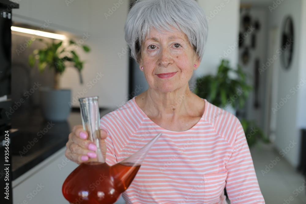 Senior woman drinking with traditional Spanish utensil called Senior woman drinking with traditional Spanish utensil called
