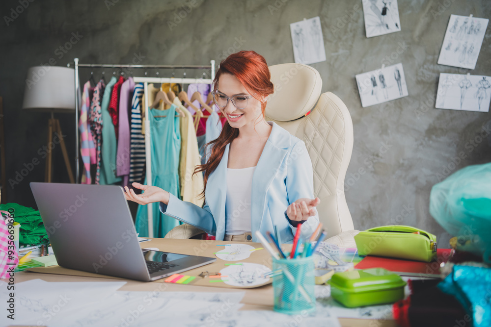 Photo of shop assistant girl sit in office store using netbook for talking client Photo of shop assistant girl sit in office store using netbook for talking client