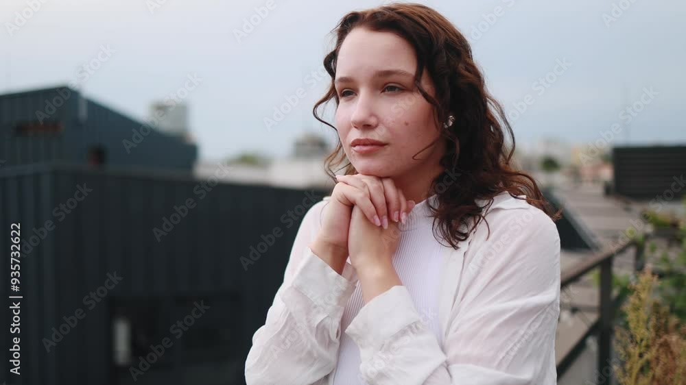 Portrait of hopeful young caucasian woman clasping hands in prayer asking for blessing and help with cloudy sky on background at balcony outdoors Religion and faith concept Portrait of hopeful young caucasian woman clasping hands in prayer asking for blessing and help with cloudy sky on background at balcony outdoors Religion and faith concept