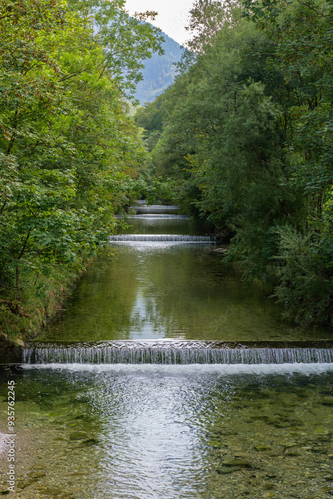 Obraz premium alpine river stepped waterfall in summer