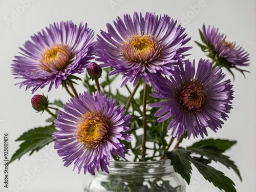 A delicate arrangement of vibrant purple aster flowers elegantly displayed in a glass jar