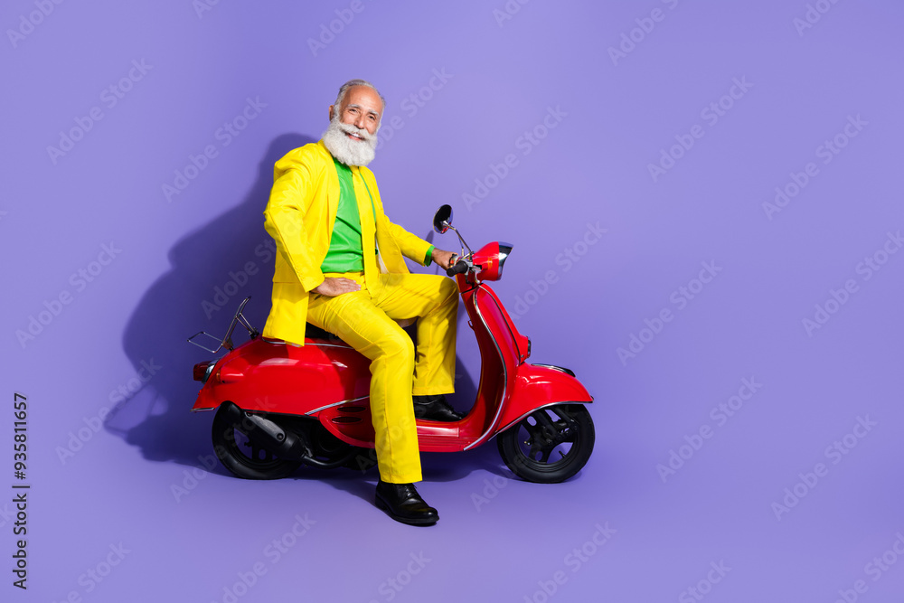 Photo of cheerful extravagant senior man wearing yellow trendy costume sitting moped isolated on purple color background Photo of cheerful extravagant senior man wearing yellow trendy costume sitting moped isolated on purple color background