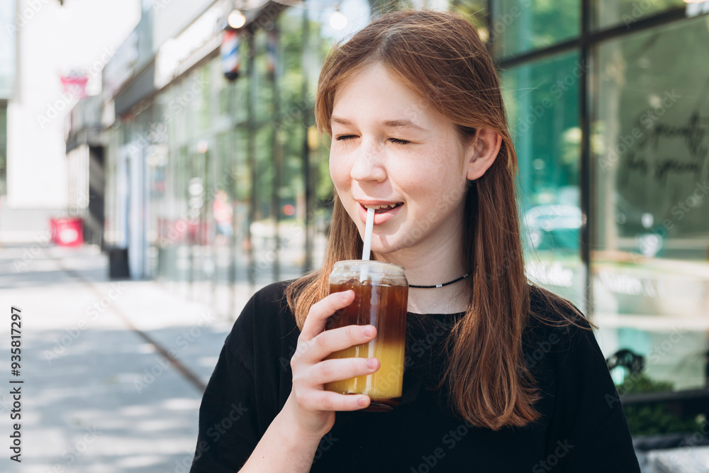 Young girl are drinking a delicious cold coffee with orange juice outdoors. Young girl are drinking a delicious cold coffee with orange juice outdoors.
