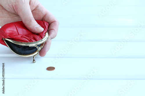 one coin fell out of the red purse in the hand. the last money ran out photo