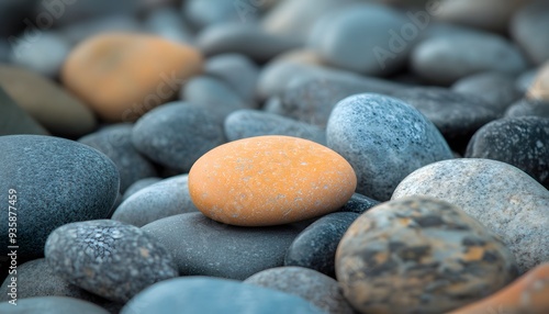 A Single Orange Stone Amongst Gray Pebbles