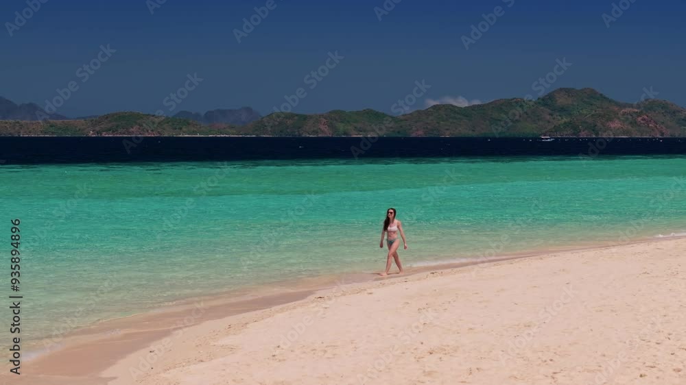 Aerial drone view of woman walking on tropical beach island in Philippines. Travel video of tourist woman relaxing and enjoying beach paradise during summer holiday Aerial drone view of woman walking on tropical beach island in Philippines. Travel video of tourist woman relaxing and enjoying beach paradise during summer holiday