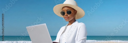 Woman Working on Laptop at the Beach - A woman wearing a white sun hat and sunglasses works on her laptop on the beach. The image symbolizes work-life balance, remote work, summer vacation, and relaxa photo