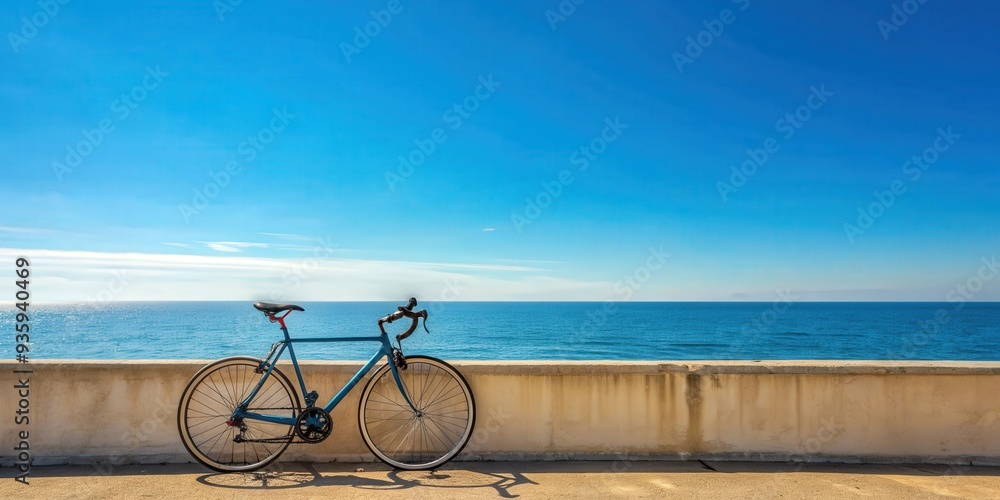 Fototapeta premium Road bicycle parked against a wall by the seaside with a clear blue sky backdrop, road bicycle, wall, seaside