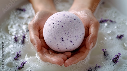 Woman holding a lavender bath bomb in a bubble bath