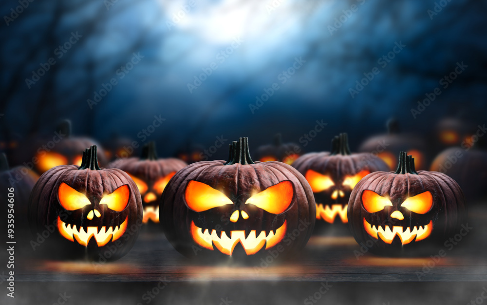 A collection of glowing halloween pumpkins, spooky Jack O' Lanterns, with copy space above on a scary halloween night.