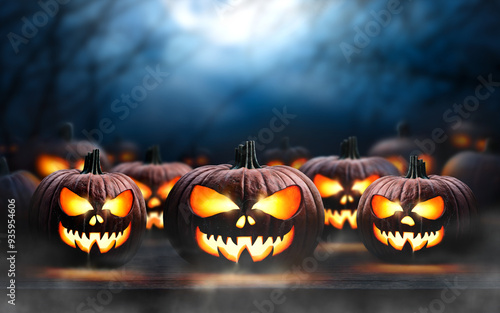 Obraz na płótnie A collection of glowing halloween pumpkins, spooky Jack O' Lanterns, with copy space above on a scary halloween night. w salonie