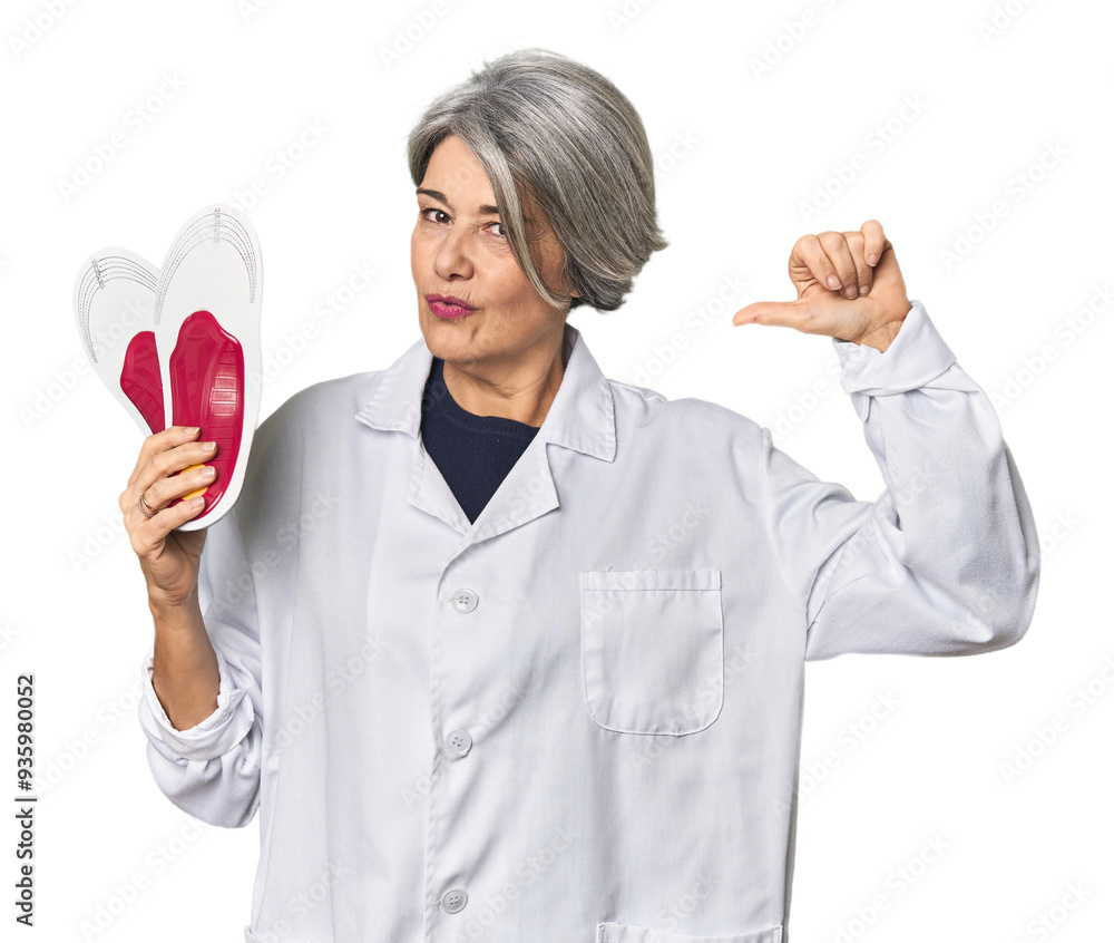 Caucasian mid-age female podiatrist holding insole feels proud and self confident, example to follow. Caucasian mid-age female podiatrist holding insole feels proud and self confident, example to follow.