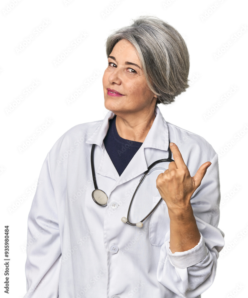 Caucasian mid-age female doctor with stethoscope pointing with finger at you as if inviting come closer. Caucasian mid-age female doctor with stethoscope pointing with finger at you as if inviting come closer.