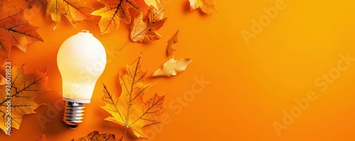 LED light bulbs in the lower left corner, with falling leaves in the upper right corner, on a warm orange background.