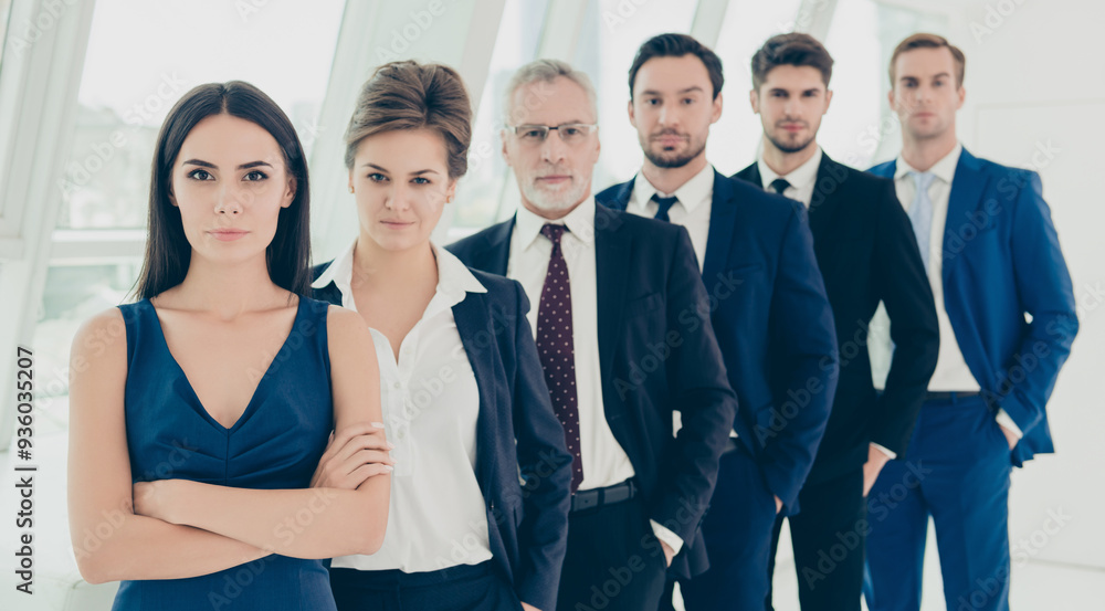 Successful serious business people standing in row in office Successful serious business people standing in row in office
