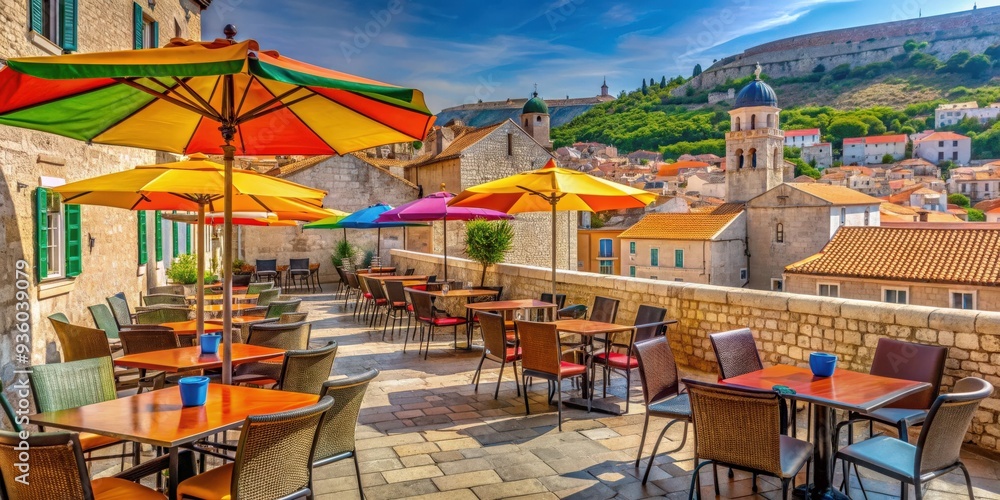 Naklejka premium Open street terrace cafe with colorful umbrellas and tables overlooking the historic buildings of Dubrovnik