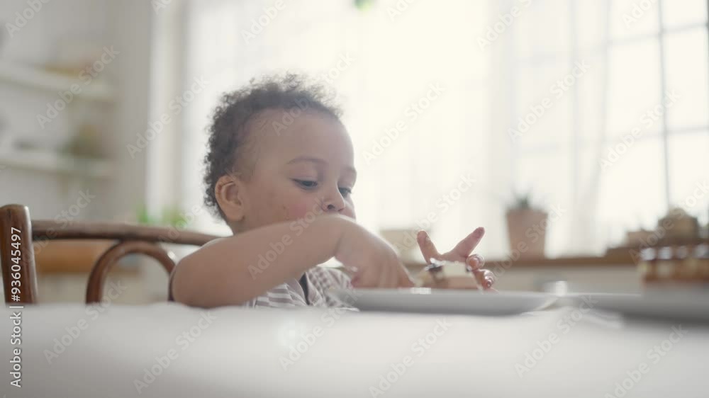 Breakfast at home in Sunday morning, portrait of cute black toddler eating cake. Happy and carefree childhood, diet nutrition for babies in early age, infancy, African American ethnicity, mixed race Breakfast at home in Sunday morning, portrait of cute black toddler eating cake. Happy and carefree childhood, diet nutrition for babies in early age, infancy, African American ethnicity, mixed race
