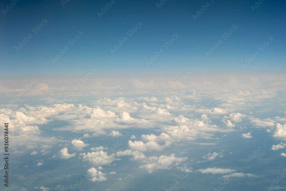 View from a Flying Airplane Over Clouds and Horizon View from a Flying Airplane Over Clouds and Horizon
