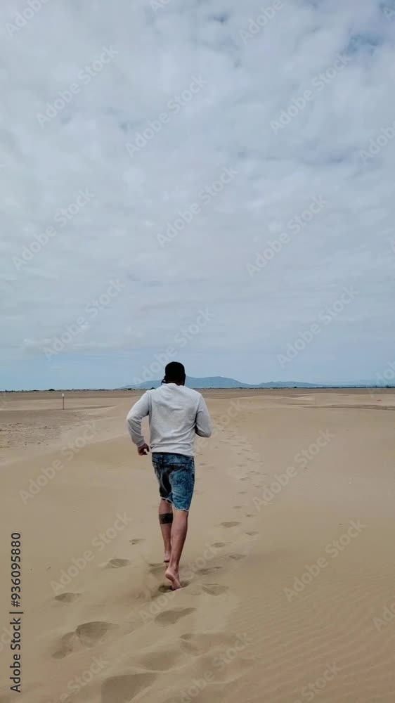 Man running through the dunes in slow motion Man running through the dunes in slow motion